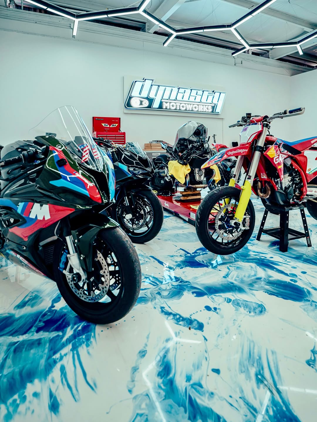 Dynasty Motoworks — BMW M1000RR, Yamaha race bike, and Honda CRF supermoto in the Dynasty bay